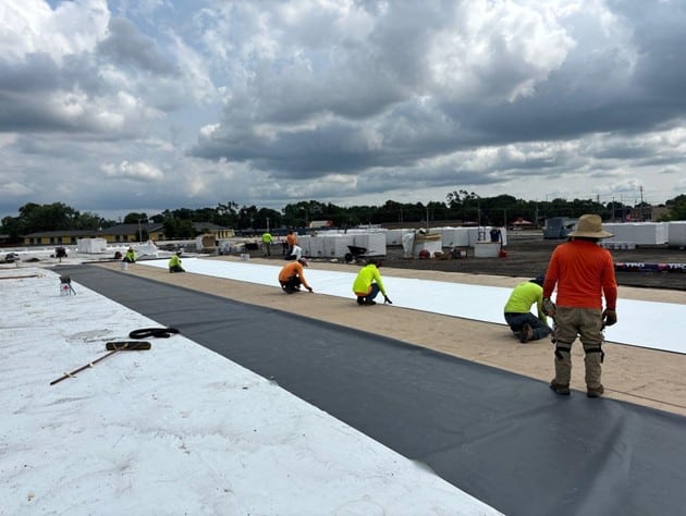 Commercial roofers working on roof